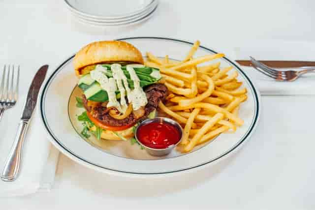 Gourmet burger and fries on outdoor patio for corporate networking lunch