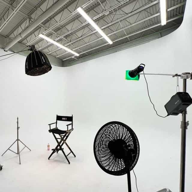 Producer's meeting in minimalist studio with white backdrop for filming and live events.
