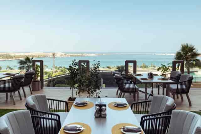Outdoor dining area at Sofitel Abu Dhabi with stunning panoramic water views for events.