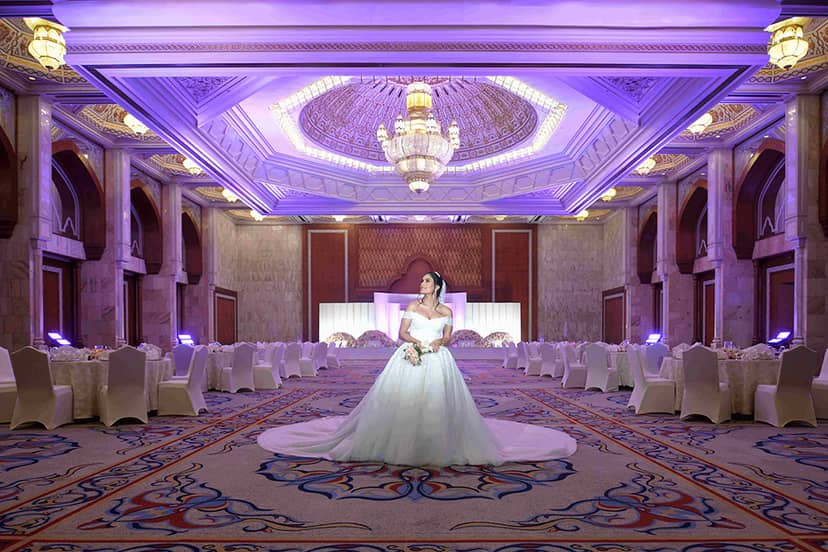 Elegant wedding banquet hall with soft purple lighting at InterContinental Abu Dhabi.