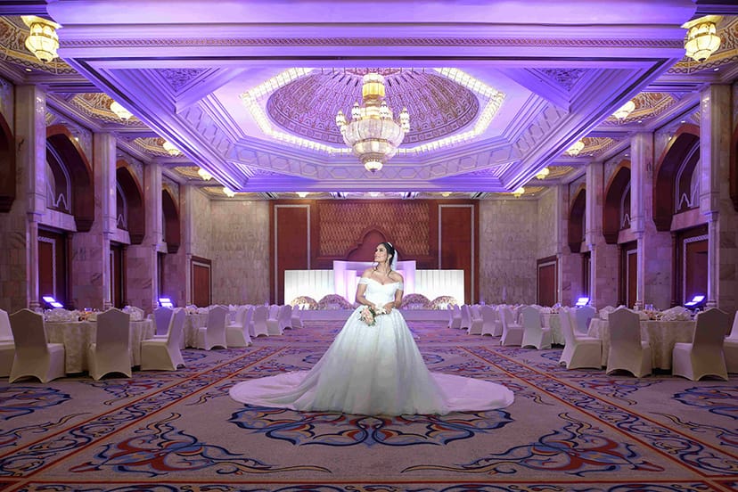 Elegant wedding banquet hall with soft purple lighting at InterContinental Abu Dhabi.