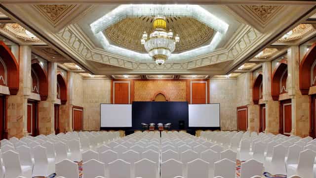 Auditorium at InterContinental Abu Dhabi with elegant chandelier, ideal for conferences.