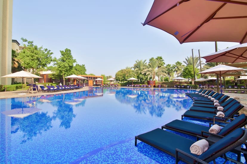 Poolside at Abu Dhabi Golf Club with lounge chairs, ideal for outdoor events and networking.