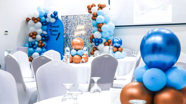 Elegant ballroom setup with blue and bronze decor for corporate and celebratory events.