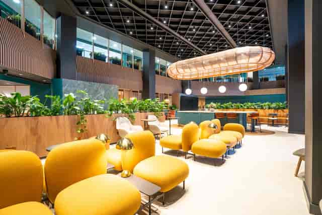 Modern business lounge with vibrant yellow seating, perfect for networking events.