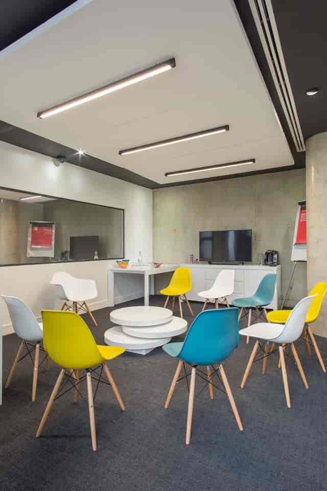 Modern meeting space with colorful chairs for creative workshops and team collaboration.