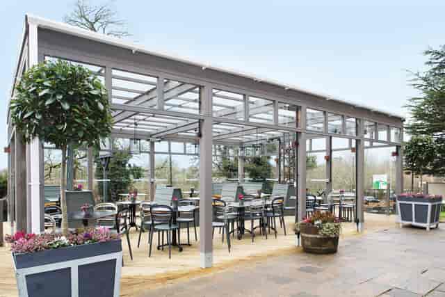 Modern glass-paneled outdoor venue for corporate meetings and social events.