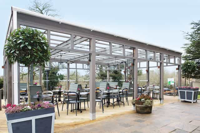 Modern glass-paneled outdoor venue for corporate meetings and social events.
