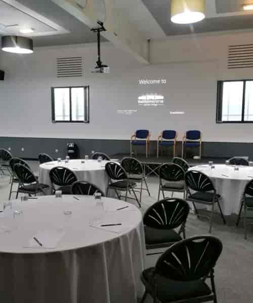 Conference room at Bridge School set for workshop with round tables and natural light.