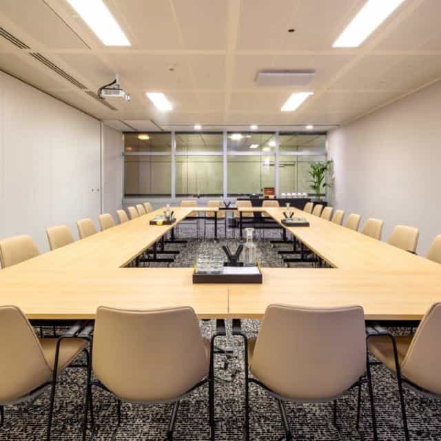 Modern conference room with large table, ideal for meetings and workshops.