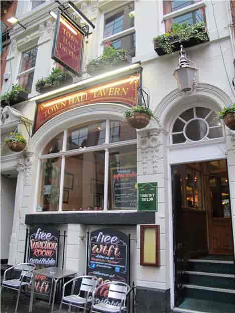 Cozy Town Hall Tavern bar with hanging plants, perfect for informal networking events.