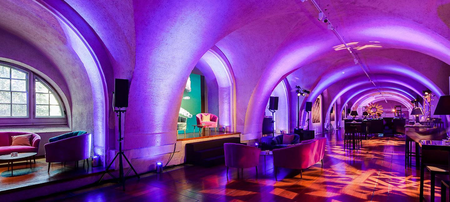 Chic event space with elegant arches and purple lighting, perfect for upscale gatherings. - Banner
