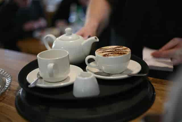 Elegant coffee service for events at Bus Stop Cafe with cappuccino and teapot.