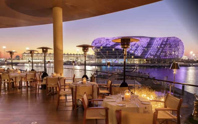 Outdoor dining at Cipriani Yas Island, elegant setup by waterfront for upscale events.