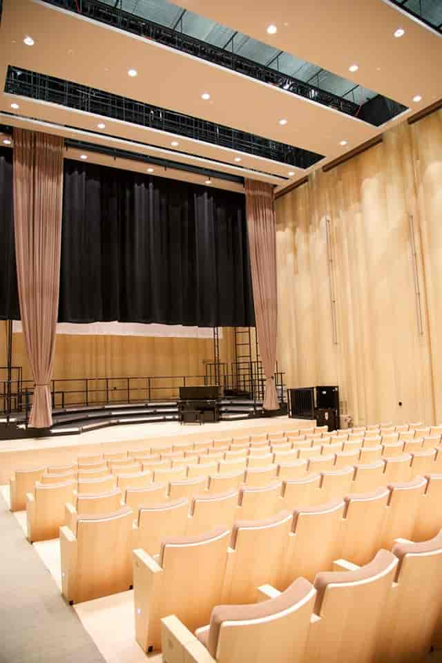 Blue Hall stage in Performing Arts Center with tiered seating, ideal for concerts and presentations.