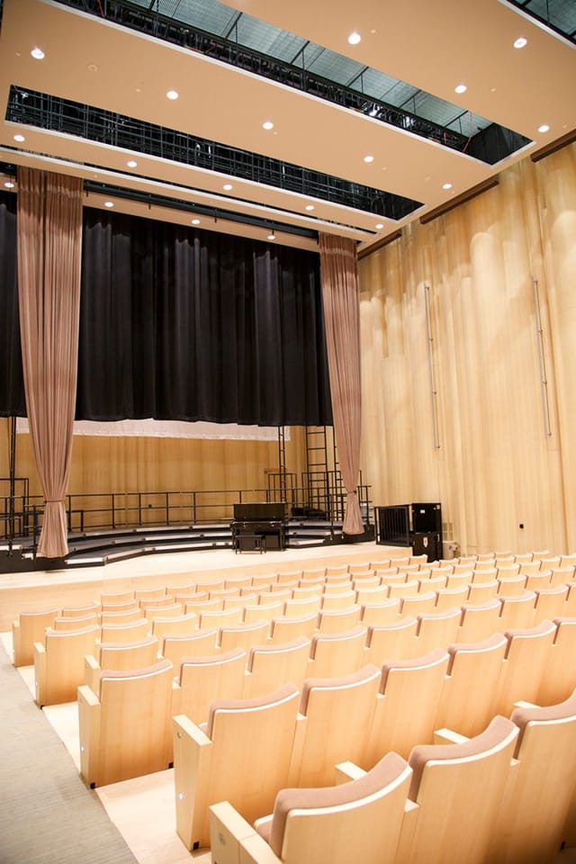 Blue Hall stage in Performing Arts Center with tiered seating, ideal for concerts and presentations.