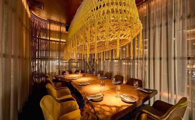 Elegant dining space at Hunter & Barrel Abu Dhabi with macramé light fixture for upscale events.