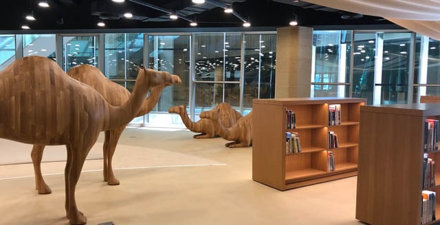 Children's library with wooden camel sculptures, perfect for creative workshops and brainstorming.