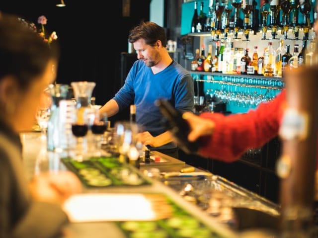 Bartender crafting drinks at BIMHUIS cafe, perfect for networking and social events.