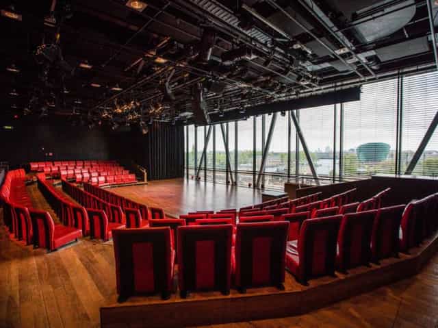 Modern Jazz club auditorium with tiered red seating for corporate events and conferences.