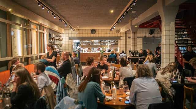 Vibrant Choux Amsterdam dining space with open kitchen for networking events and private dinners.
