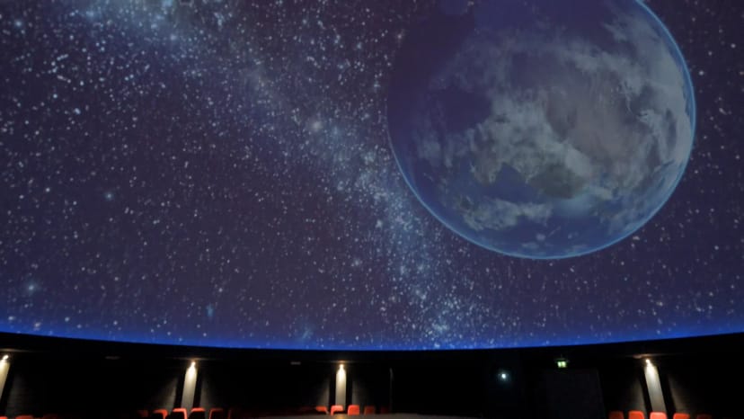 "Planetarium venue with starry dome and red seating for corporate events and presentations."