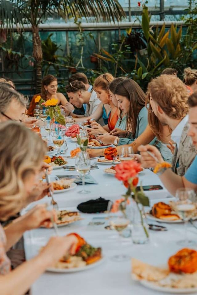BBQ event at Hummus & Habibis with vibrant floral centerpieces and engaged attendees.