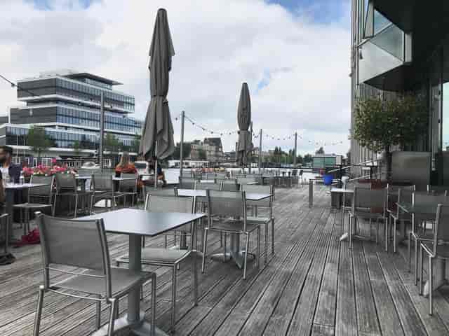 Outdoor waterfront terrace at Ode aan de Amstel for networking and casual meetings.