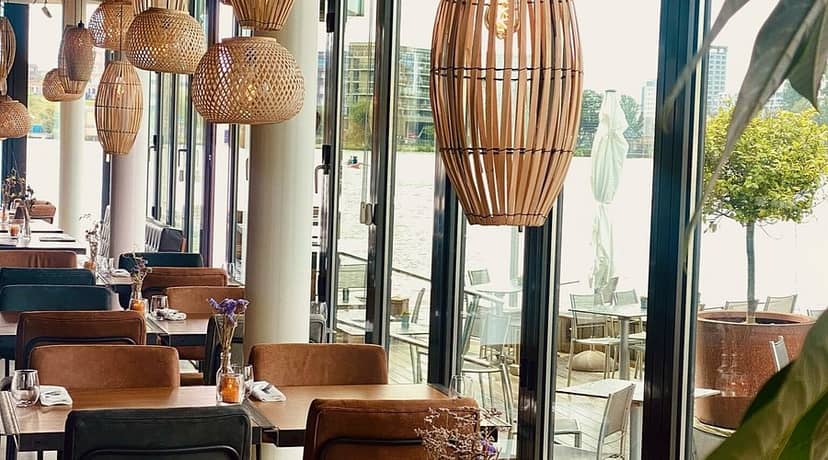 Stylish waterfront restaurant with modern decor, ideal for events and gatherings.
