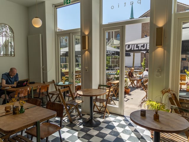 Light-filled café patio with outdoor seating for casual meetings and networking events.