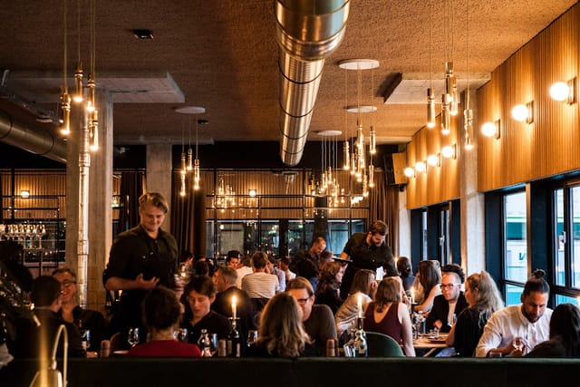 Vibrant restaurant with warm lighting, perfect for corporate events and networking lunches.