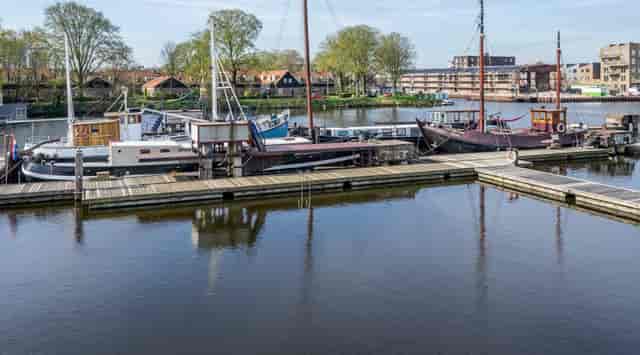 Crossboat at De Ceuvel: serene waterfront for outdoor events amidst lush greenery.