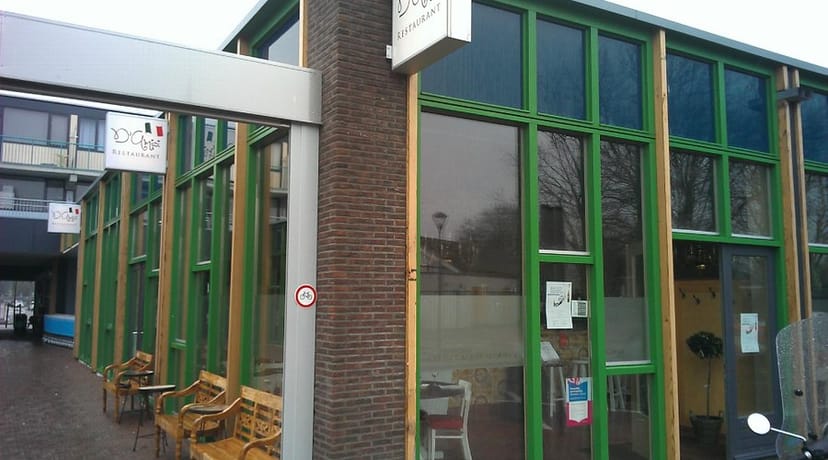 Modern lounge in D'Amici Vleuten with large green-framed windows for events and workshops.