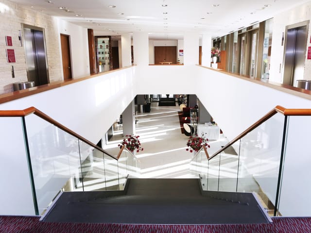 Modern atrium with open staircase at Crowne Plaza Amsterdam-South conference center.