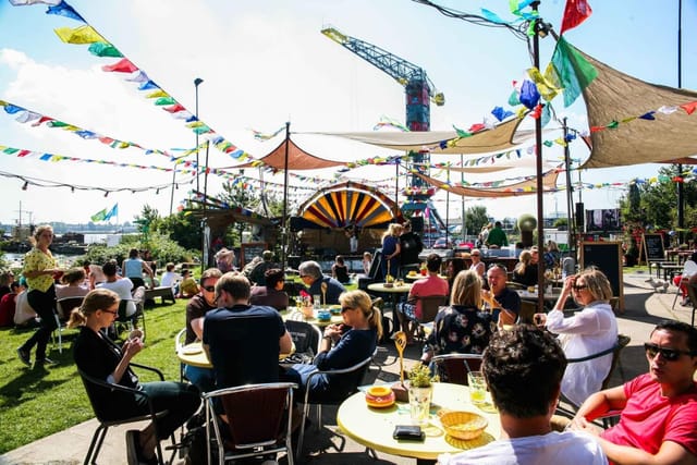 Vibrant outdoor event at Café Noorderlicht with colorful decorations and lively guests.