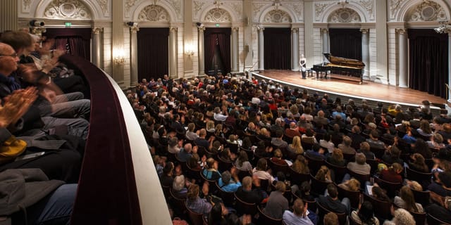 Packed Recital Hall at The Royal Concertgebouw, showcasing elegant architecture for events.