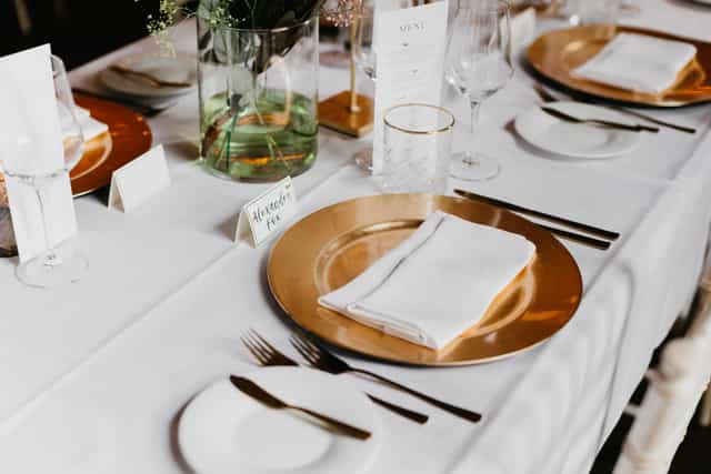 Elegant table setting with gold charger in The College Hotel Amsterdam for upscale events.