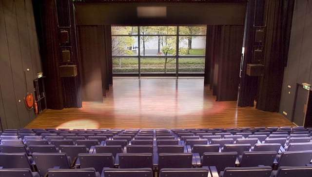 Spacious Meervaart Theater auditorium with polished stage for events and performances.