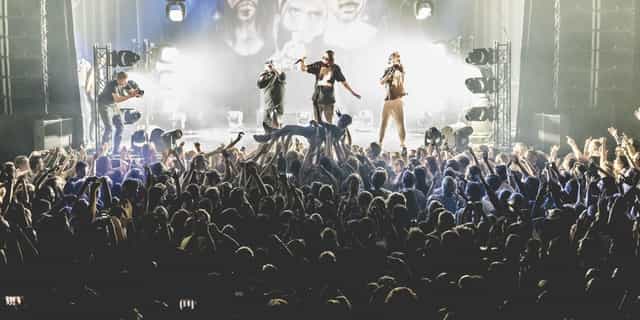 OZ concert at Melkweg with vibrant lighting and engaged audience energy.