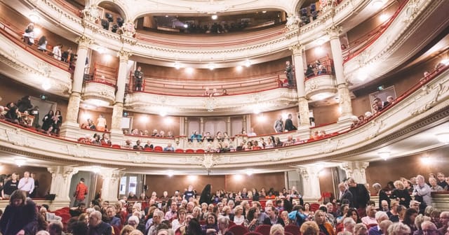 Grote Zaal, ornate Amsterdam theater, filled audience for an elegant performance event.