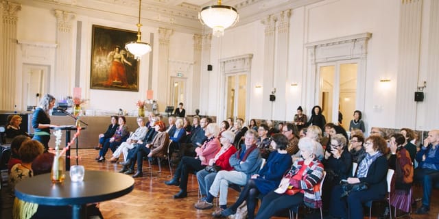 Elegant Koninklijke Foyer at Internationaal Theater Amsterdam during a vibrant lecture event.