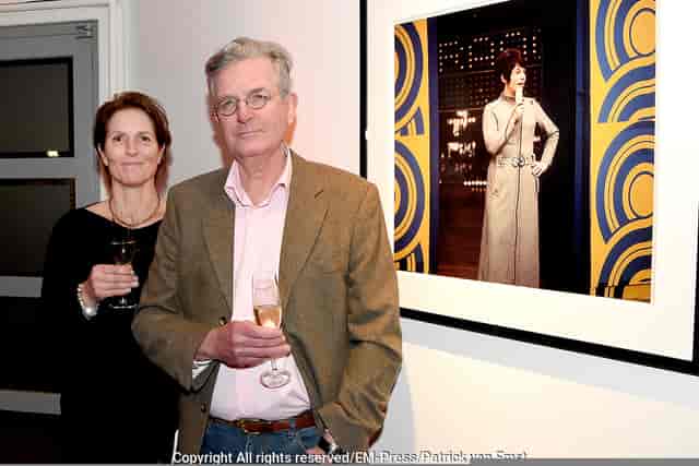 Networking event in art gallery with attendees enjoying drinks and conversation.