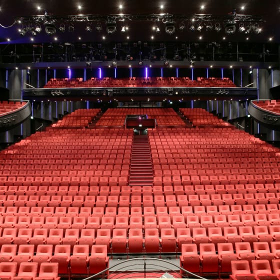 Spacious Beatrix Theatre Expo Room with tiered red seating for conferences and performances.