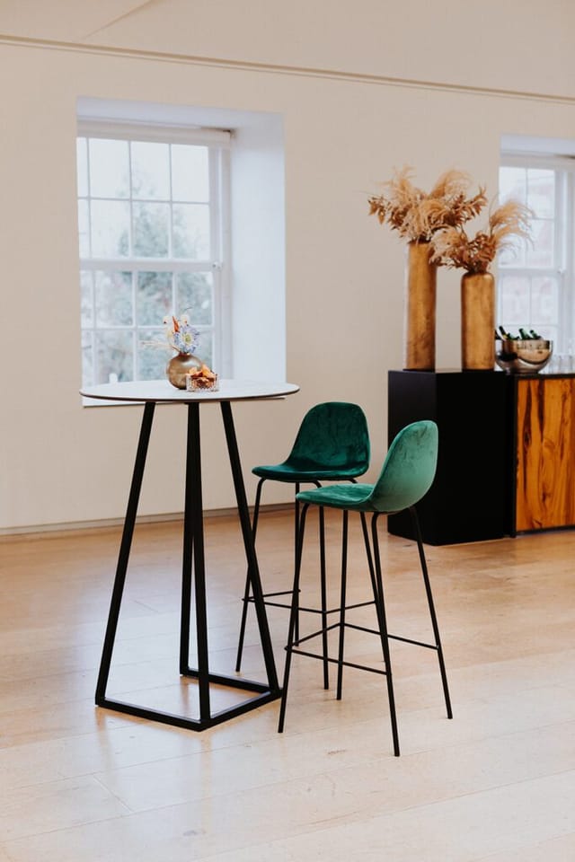 Auditorium at H'ART Museum with high table and green chairs for networking events.
