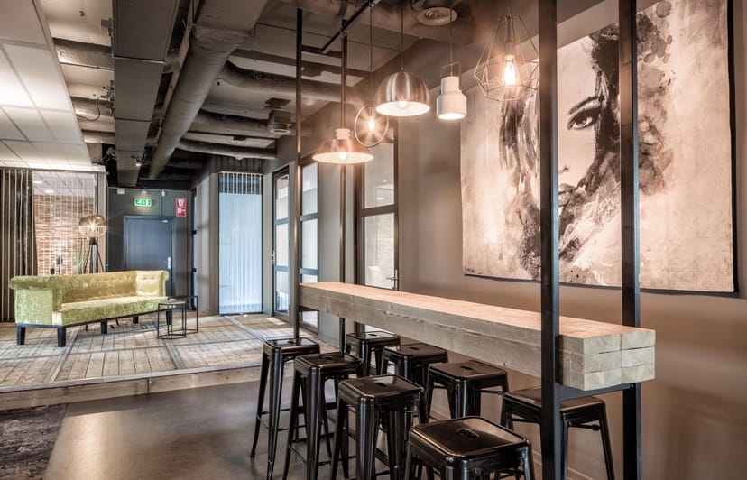 Modern event space in StudioZoost with communal table, ideal for meetings and networking.