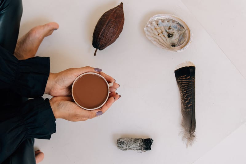 Cacao ceremony setup with warm beverage for wellness retreat in nature-inspired setting.
