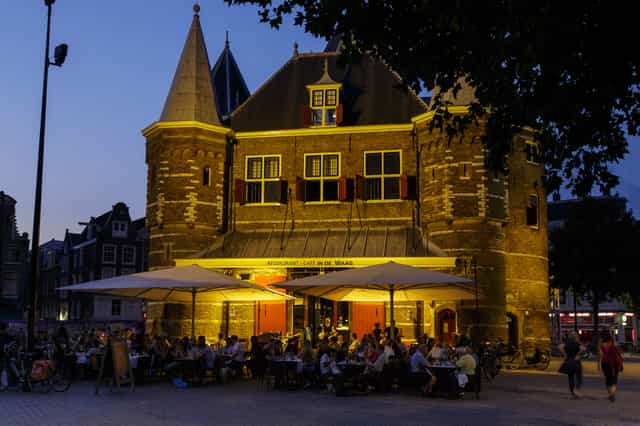 Charming Waag restaurant with outdoor seating, ideal for evening events and gatherings.