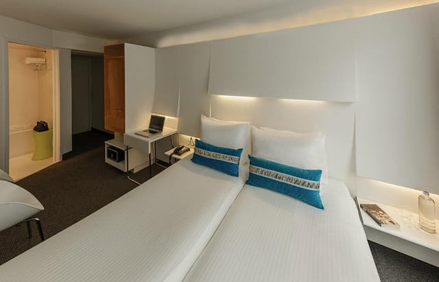 Modern twin guest room at ibis Styles Amsterdam for business and event attendees.