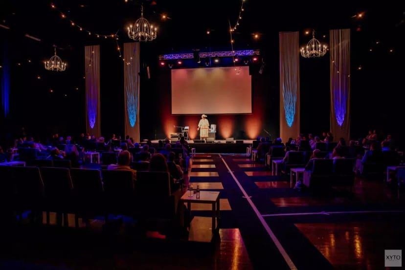 Modern conference venue in Middenzaal with stage and audience seating for events.
