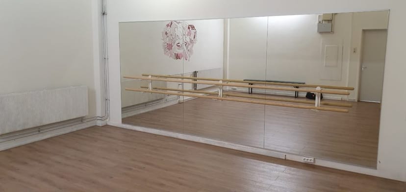 Bright minimalist dance studio with mirrored walls for workshops and fitness classes.